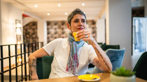 stock image One woman senior caucasian female sit at cafe or restaurant have a cup of coffee real people copy space modern gray short hair person sitting alone