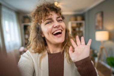 Beyaz bir kadın, kendinden emin, evde kıvırcık saçlı, mutlu, gülümseyen gerçek bir insan, uzay portresi, UGC Kullanıcı İçeriği
