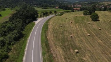 Güneşli bir günde asfalt bir yolun manzaralı güzelliği İHA 'nın perspektifinden geçen arabaların asfalt hava aracının Sırbistan' daki bakış açısıyla sürüşü.