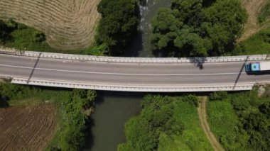 Güneşli bir günde asfalt bir yolun manzaralı güzelliği. Hava aracının perspektifinden geçen bir araç asfalt hava aracıyla Sırbistan 'da nehri geçen köprüden karşıya geçiyor.