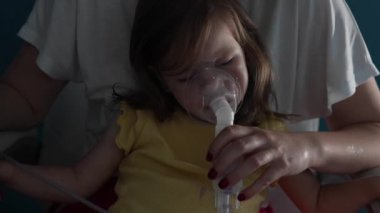 Evde nebulizör kullanan bir çocuk. Buhar buharı soluyan maske kullanan küçük bir kız çocuğu. Evde tıbbi müdahale, astım tedavisi, zatürree bronşit seçici odaklanma.