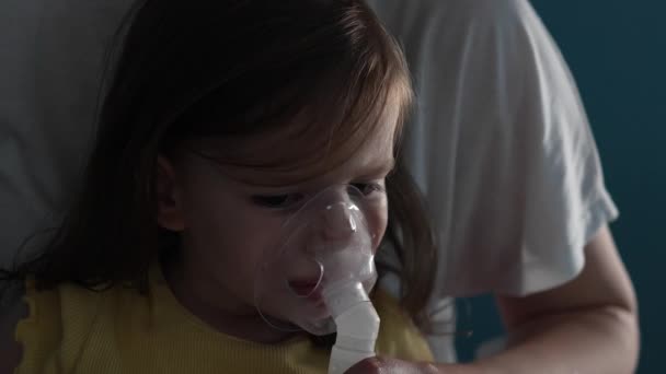 自宅でネブライザーを使う1人の幼児自宅で蒸気吸入器マスク吸入を使う医療処置喘息肺炎気管支炎選択的フォーカス — ストック動画