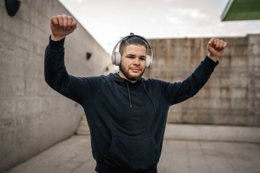 Yetişkin beyaz bir adam, günlük egzersiz rutininde lastik elastik direnç tüpleri kullanarak şehir dışında antrenman yapıyor. Gerçek insan sağlığı ve fitness konsepti kopyalama alanı kullanıyor.