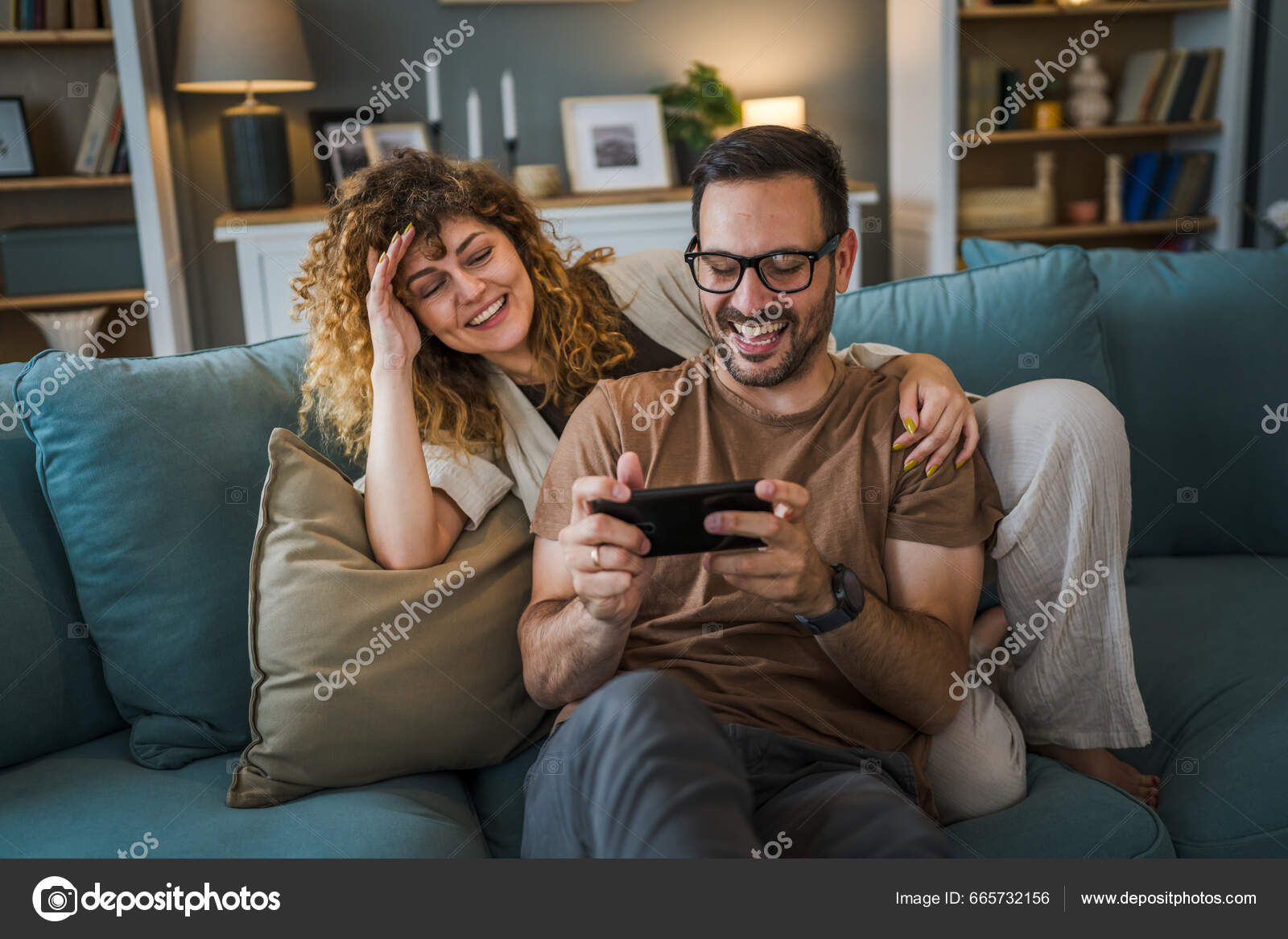 Happy boyfriend and girlfriend playing video games and holding