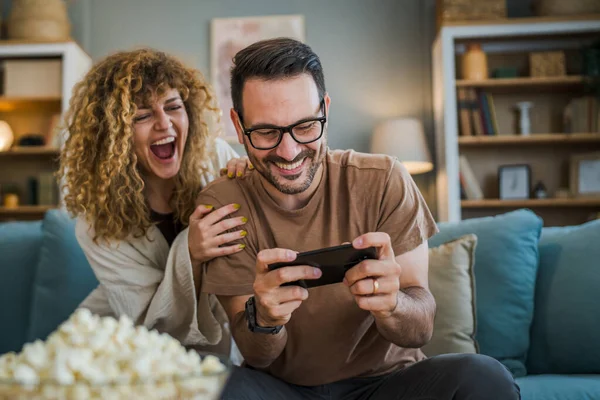 一对成年夫妇 男人和女人 高加索人的丈夫和妻子 男朋友和女朋友 他在家里玩电子游戏 拿着手机 智能手机 享受着乐趣 享受着结合的概念复制的空间 — 图库照片