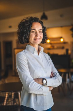 Yetişkin bir kadın Kafkas kadın iş kadını iş yerinde ya da evde duruyor gerçek insanlar yer kopyalıyor beyaz gömlek kıvırcık saçlar giyiyor