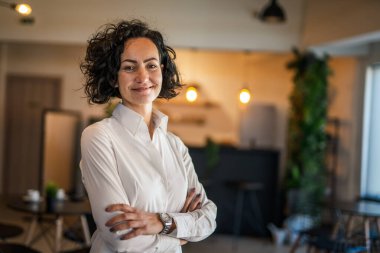 Yetişkin bir kadın Kafkas kadın iş kadını iş yerinde ya da evde duruyor gerçek insanlar yer kopyalıyor beyaz gömlek kıvırcık saçlar giyiyor