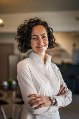 Yetişkin bir kadın Kafkas kadın iş kadını iş yerinde ya da evde duruyor gerçek insanlar yer kopyalıyor beyaz gömlek kıvırcık saçlar giyiyor