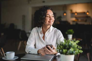 İş yerindeki kadın yönetici ya da girişimci cep telefonu akıllı telefonu kullanır iş kadını iletişim konseptinden fren alırken beyaz gömlek giyer gerçek kişi kopyalama alanı SMS mesajları gönderir