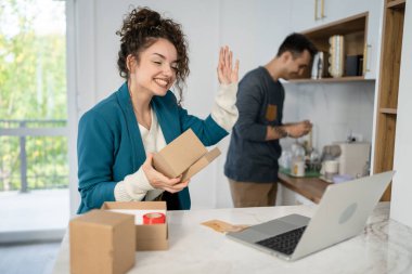 Kafkasyalı genç bir çift, karı-koca, karı-koca ya da sevgili evde bilgisayarın önünde hediye kutusunu açıp internetten fotokopi çekiyorlar.