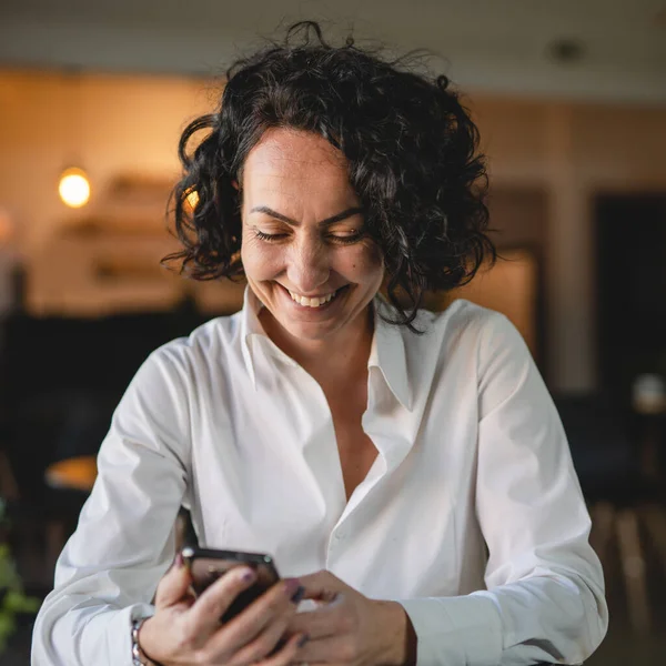 女经理或女企业家在工作中使用手机智能手机穿白衬衫 同时刹车女商人交流理念实话实说复制空间发送短信 — 图库照片