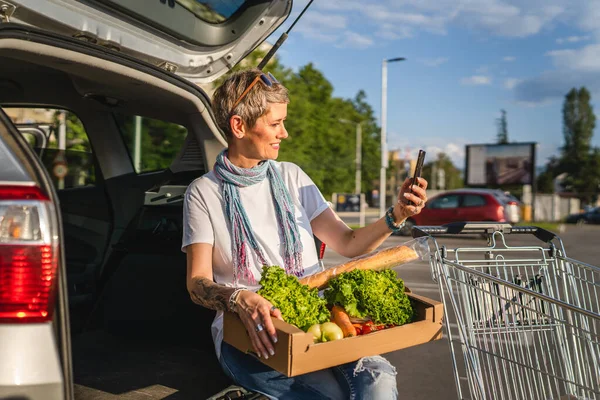 여자는 자동차 야채를 자동차 슈퍼마켓이나 식료품 주차장에 — 스톡 사진