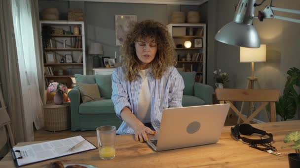 自宅のノートパソコンで仕事をしているある女性はゆっくりとした動きをリラックスさせ — ストック動画