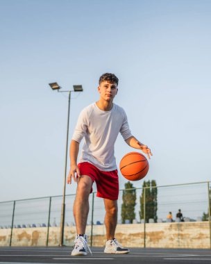 Kafkas asıllı bir genç adam basketbol sahasında duruyor. Akşamları elinde top, fotokopi çekmeye hazır. Gerçek insan.
