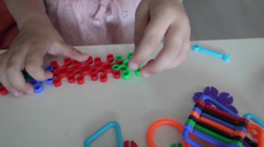 Bilinmeyen çocukların ellerini birbirine kenetlenmiş plastik oyuncaklarla oynat