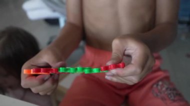 Bilinmeyen çocukların ellerini birbirine kenetlenmiş plastik oyuncaklarla oynat
