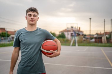 Kafkas asıllı bir genç adam basketbol sahasında duruyor. Akşamları elinde top, fotokopi çekmeye hazır. Gerçek insan.