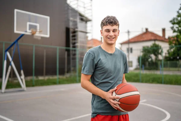一个少年高加索男子高加索青年男子带着球站在篮球场上 准备打比赛场地的实人实相 — 图库照片