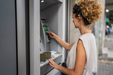 Kadın kredi kartı kullanıyor ve ATM 'den para çekiyor.