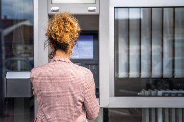 Kadın kredi kartı kullanıyor ve ATM 'den para çekiyor.
