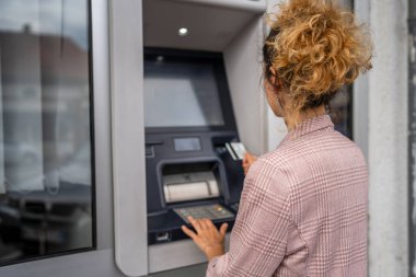 Kadın kredi kartı kullanıyor ve ATM 'den para çekiyor.