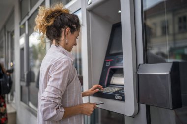 Kadın kredi kartı kullanıyor ve ATM 'den para çekiyor.