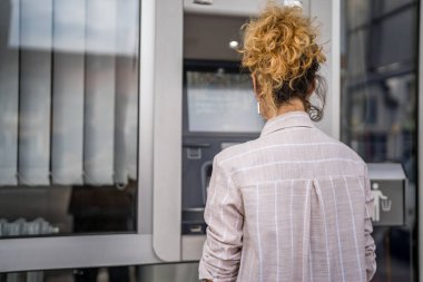 Kadın kredi kartı kullanıyor ve ATM 'den para çekiyor.