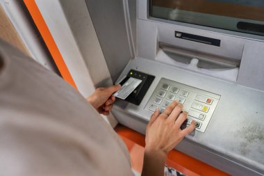 Kredi kartı kullanan ve ATM 'den para çeken bir kadının elleri.