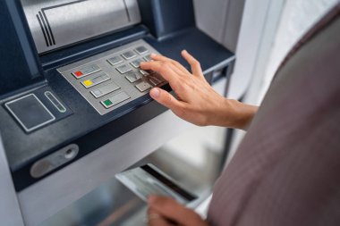 Kredi kartı kullanan ve ATM 'den para çeken bir kadının elleri.