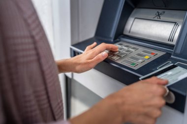 Kredi kartı kullanan ve ATM 'den para çeken bir kadının elleri.