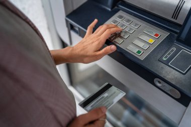 Kredi kartı kullanan ve ATM 'den para çeken bir kadının elleri.