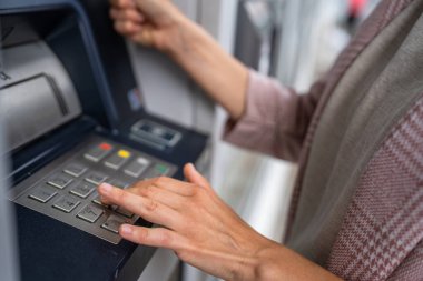 Kredi kartı kullanan ve ATM 'den para çeken bir kadının elleri.