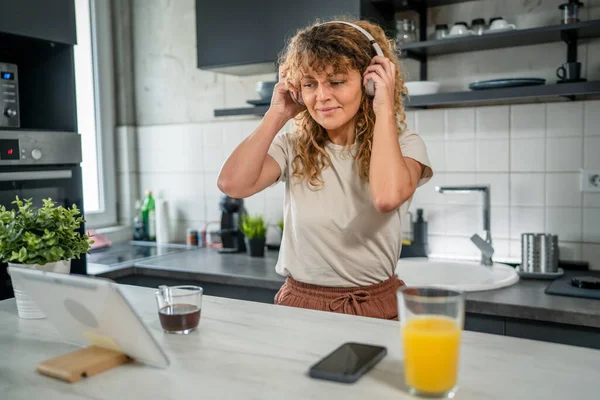 Jedna Běloška Kudrnatými Vlasy Sedět Doma Pomocí Digitálních Tablet Sluchátek — Stock fotografie