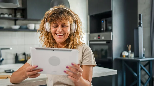 Jedna Běloška Kudrnatými Vlasy Sedět Doma Pomocí Digitálních Tablet Sluchátek — Stock fotografie