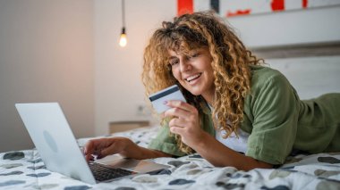 Evde yetişkin bir kadın online alışveriş için kredi kartı ya da banka kartı kullanıyor. İnternet mağazaları indirimli indirimli indirimli ürünler alıyor. Gerçek insanlar yer bilgisayarlarını kopyalıyor.