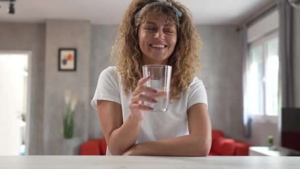 大人の白人女性が自宅に座って水のグラスハッピー笑顔 — ストック動画