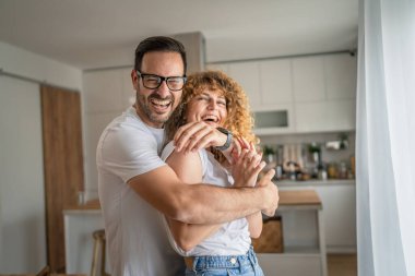Mutlu Kafkasyalı yetişkin çift evde birlikte gülümsüyor karı koca ya da sevgili olarak eğleniyorlar.