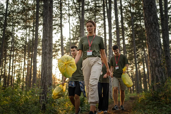 成群结队的青少年朋友一男一女高加索人一男一女从森林里捡起废塑料瓶和废纸 在阳光明媚的日子里清扫大自然环境保护生态的理念 — 图库照片