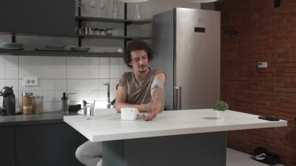 Beyaz Bir Erkek Masada Oturuyor Kan Basıncını Ölçmek Için Evde — Stok video