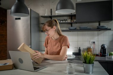 Beyaz bir kadın, online alışveriş ürünlerinin nakliye detaylarını kontrol etmek için akıllı telefon kullanıyor. Akıllı telefon uygulaması başvurusunu kontrol edin. Çevrimiçi detaylar mutlu bir gülümseme.