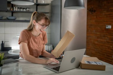 Beyaz bir kadın, online alışveriş ürünlerinin nakliye detaylarını kontrol etmek için akıllı telefon kullanıyor. Akıllı telefon uygulaması başvurusunu kontrol edin. Çevrimiçi detaylar mutlu bir gülümseme.