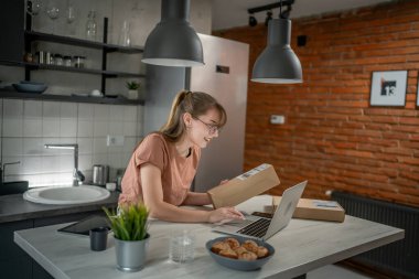 Beyaz bir kadın, online alışveriş ürünlerinin nakliye detaylarını kontrol etmek için akıllı telefon kullanıyor. Akıllı telefon uygulaması başvurusunu kontrol edin. Çevrimiçi detaylar mutlu bir gülümseme.