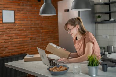 Beyaz bir kadın, online alışveriş ürünlerinin nakliye detaylarını kontrol etmek için akıllı telefon kullanıyor. Akıllı telefon uygulaması başvurusunu kontrol edin. Çevrimiçi detaylar mutlu bir gülümseme.