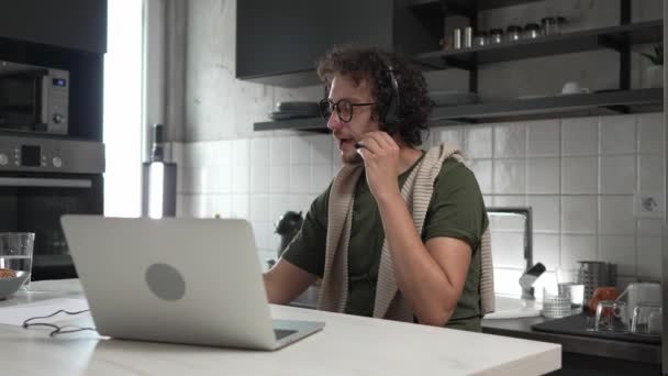 Kafkasyalı Bir Erkek Evde Kulaklıklı Bilgisayar Başında Müşteri Hizmetleri Güler — Stok video