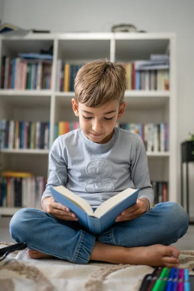 Beyaz tenli öğrenci evde ders kitabı okuyor. Okula hazırlanmayı öğrenin.