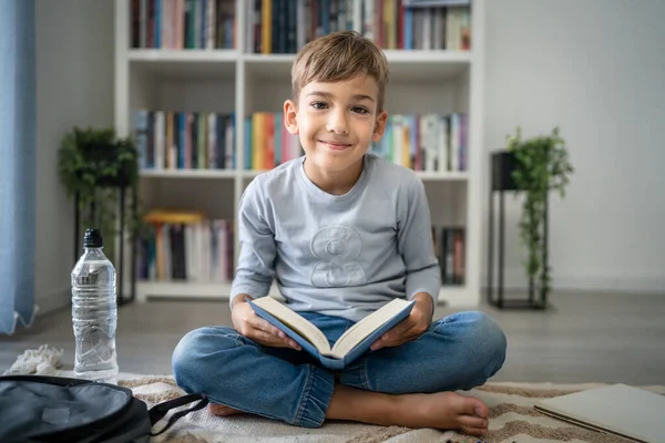 Beyaz tenli öğrenci evde ders kitabı okuyor. Okula hazırlanmayı öğrenin.