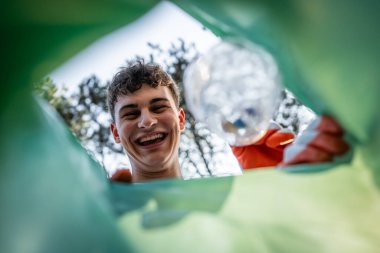Pov bakış açısı çantanın içinden genç gönüllü gençler doğanın çevre bilincinden plastik atık topluyor ve konsepti geri dönüştürüyor