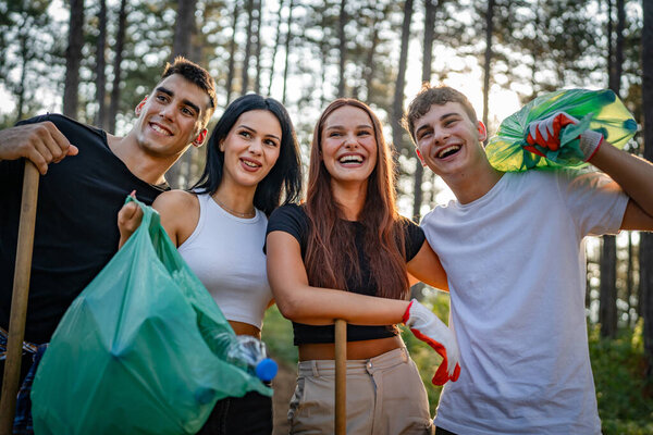 portrait of group of friends volunteers prepare to collect garbage waste and clean forest nature in summer day slow motion