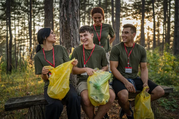 友人のグループのボランティアの肖像画は 夏の日の遅い動きでゴミやきれいな森の性質を収集する準備をします — ストック写真