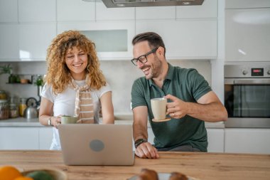 Mutlu çift Kafkasyalı yetişkin erkek ve kadın karı ve koca sabah rutini kahvaltıda evde fotokopi odasında dizüstü bilgisayar kullanın.